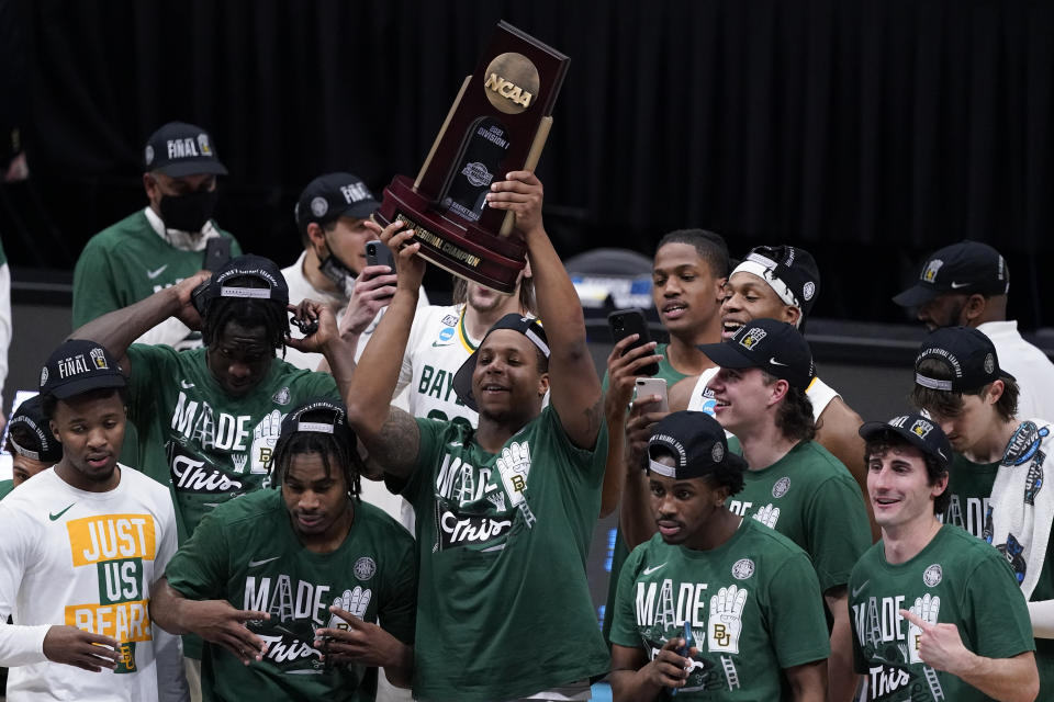 Baylor players celebrate with the trophy after an Elite 8 game against Arkansas in the NCAA men's college basketball tournament at Lucas Oil Stadium, Tuesday, March 30, 2021, in Indianapolis. Baylor won 81-72. (AP Photo/Darron Cummings)