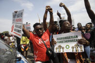 People hold banners as they demonstrate on the street to protest against police brutality in Lagos, Nigeria, Thursday Oct. 15, 2020. Protests against Nigeria's police continued to rock the country for the eighth straight day Thursday as demonstrators marched through the streets of major cities, blocking traffic and disrupting business. (AP Photo/Sunday Alamba)