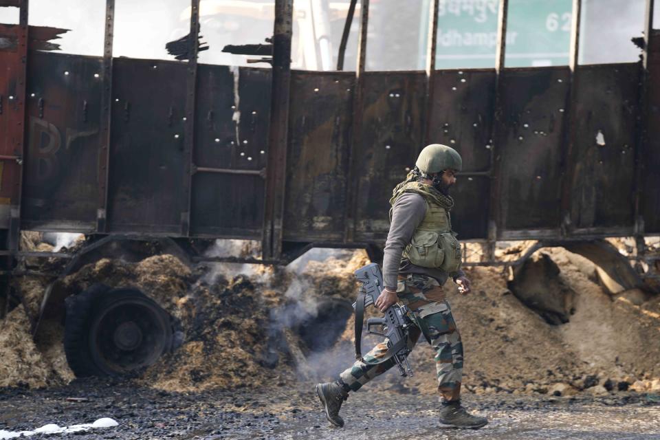 An Indian army soldier walks past the site of a gunfight at Nagrota, on the Jammu-Srinagar highway, Indian-controlled Kashmir, Wednesday, Dec. 28, 2022. A top police officer, Mukesh Singh, said troops intercepted a truck in the outskirts of Jammu city early Wednesday following its “unusual movement” on a highway. As the troops began searching the truck, gunfire came from inside it, to which the troops retaliated, leading to a gunfight killing four suspected militants, Singh told reporters. (AP Photo/Channi Anand)