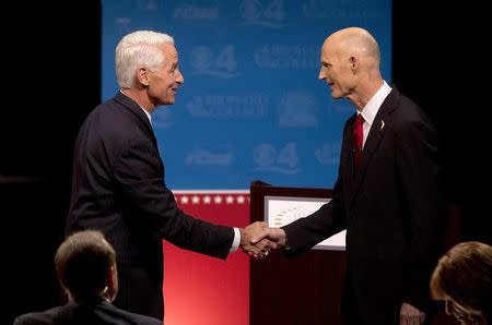 Democratic challenger, former Republican Gov. Charlie Crist (L) and Florida Republican Gov. Rick Scott, shake hands after participating in their second debate in Davie, FL, October 15, 2014. REUTERS/Wilfredo Lee/Pool