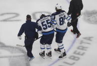 Winnipeg Jets' Mark Scheifele is helped off the ice after being injured during the first period of the team's NHL hockey playoff game against the Calgary Flames in Edmonton, Alberta, Saturday, Aug. 1, 2020. (Jason Franson/The Canadian Press via AP)