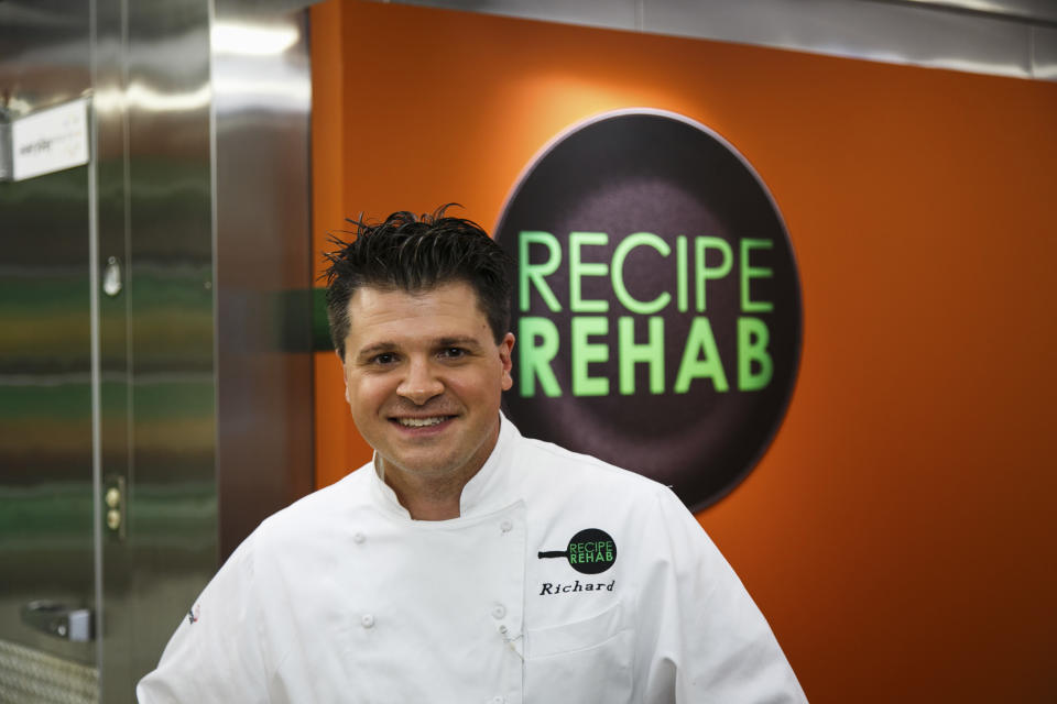 In this Aug. 18, 2013 photo provided by Trium Entertainment, Lewisburg, W. Va., resident Rich Rosendale poses in front of a Recipe Rehab sign at the studios in Calabasas, Calif. Rosendale, one of TV’s newest celebrity chefs, says his greatest challenges come on the set of "Recipe Rehab," a Saturday morning show that begins airing Sept. 28 on CBS. (AP Photo/Trium Entertainment, Venessa Stump)