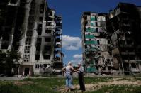 Residents chat in front of a destroyed building in Borodianka