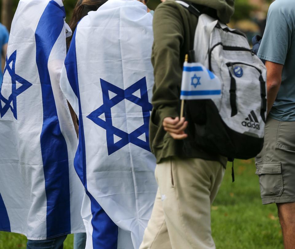 Purdue University students wear the flag of Israel on their backs at a vigil held in front of the university’s Engineering Mall, on Wednesday, October 11, 2023, in West Lafayette, Ind.