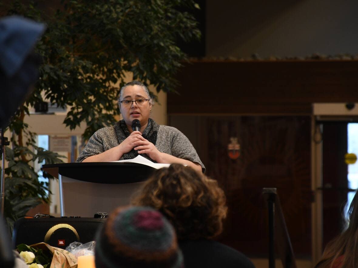 Francis van Kessel, who sits on the board of the Victoria Faulkner Women's Centre, speaks at a vigil Tuesday at the Yukon Legislative Assembly where the National Day of Remembrance and Action on Violence Against Women was marked. (Jackie Hong/CBC - image credit)