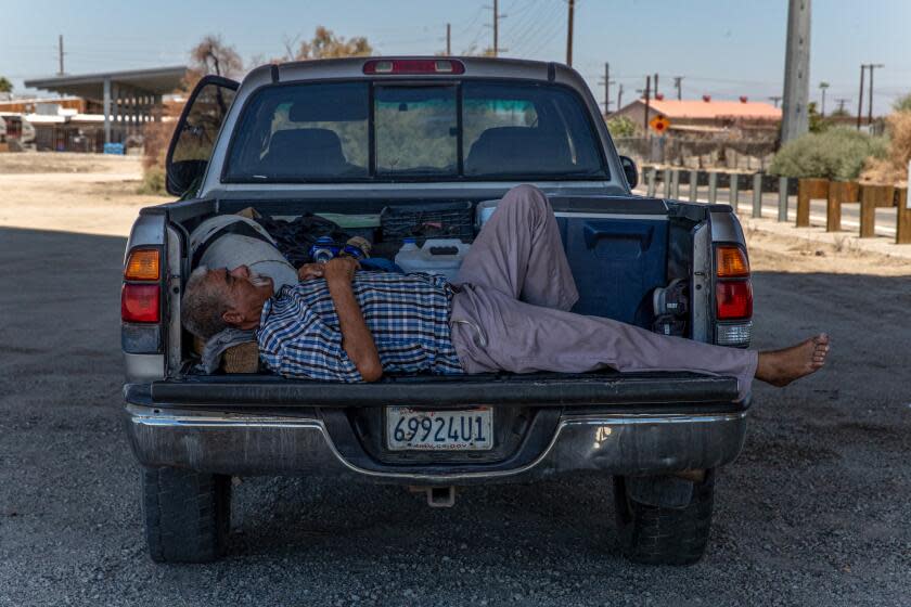 A field worker after a days hard work in intense heat sleeps under the shade of 66th. Avenue bridge in Mecca, CA.