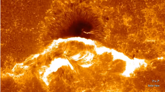 A spectacular solar flare erupts near a huge sunspot on the surface of the sun in this view from the Japanese Hinode solar observatory, which is celebrating its 10th anniversary of its Sept. 23, 2006 launch. T