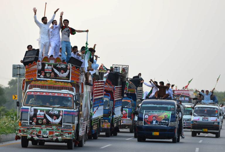 Supporters of Pakistani cricketer-turned-politician Imran Khan travel in Swabi on August 14, 2014, as they head towards Islamabad in a bid to unseat the government