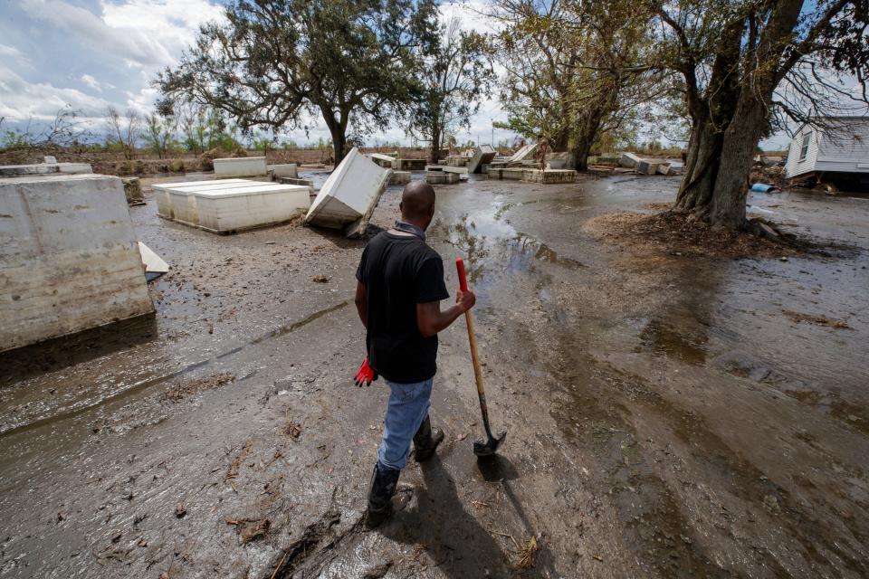 Ironton resident Kornell Davis walks through the Ironton cemetery, still covered in nearly a foot a marsh mud Sunday, Sept. 19, 2021, three weeks after the wind and storm surge from Hurricane Ida devastated the historic African community in Plaquemines Parish, La.