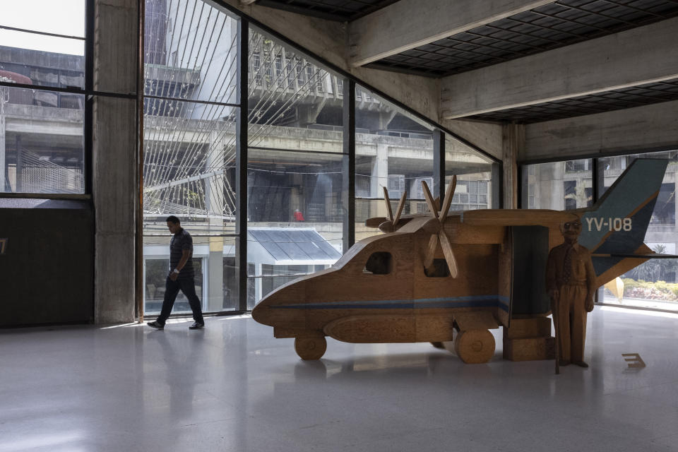 In this Sept. 17, 2019, photo, a man walks in front of Marisol Escobar's sculpture The Airplane in the Museum of Contemporary Art of Caracas, Venezuela. Today, the museum, which boasted the largest collection of contemporary art in Latin America when it was founded in the 1970s, is a shadow of its former glory. (AP Photo/Andrea Hernandez Briceño)