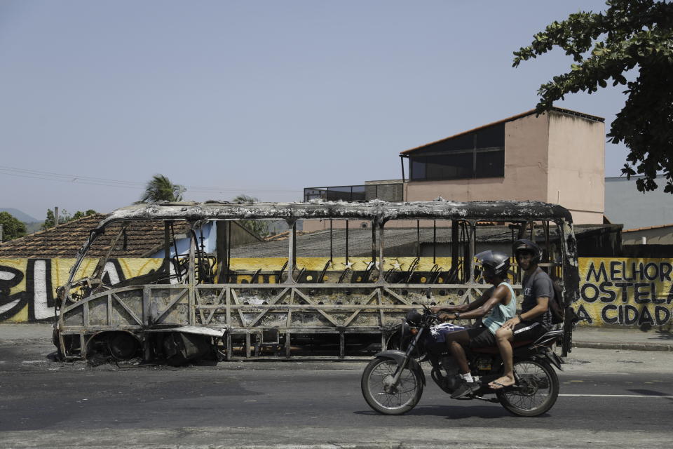 A burned bus sits idle in the street the day after it and other vehicles, train and bus stations were set fire in Rio de Janeiro, Brazil, Tuesday, Oct. 24, 2023. (AP Photo/Bruna Prado)