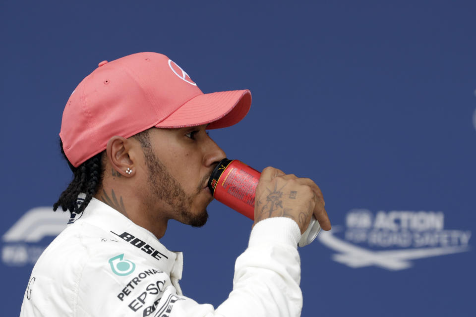 Second placed Mercedes driver Lewis Hamilton of Britain refreshes after the qualifying session at the Silverstone racetrack, in Silverstone, England, Saturday, July 13, 2019. The British Formula One Grand Prix will be held on Sunday. (AP Photo/Luca Bruno)