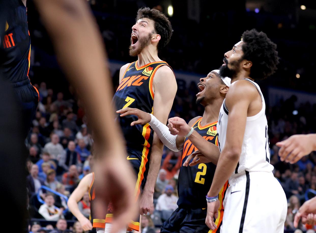 Thunder forward Chet Holmgren (7) and guard Shai Gilgeous-Alexander (2) react next to Nets guard Spencer Dinwiddie (26) during a game on Dec. 31 at Paycom Center.