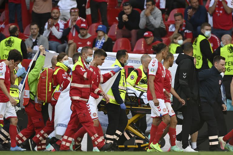 Christian Eriksen, de Dinamarca, es trasladado en camilla después de colapsarse en el campo durante el partido del grupo B por el campeonato de fútbol de la Eurocopa 2020