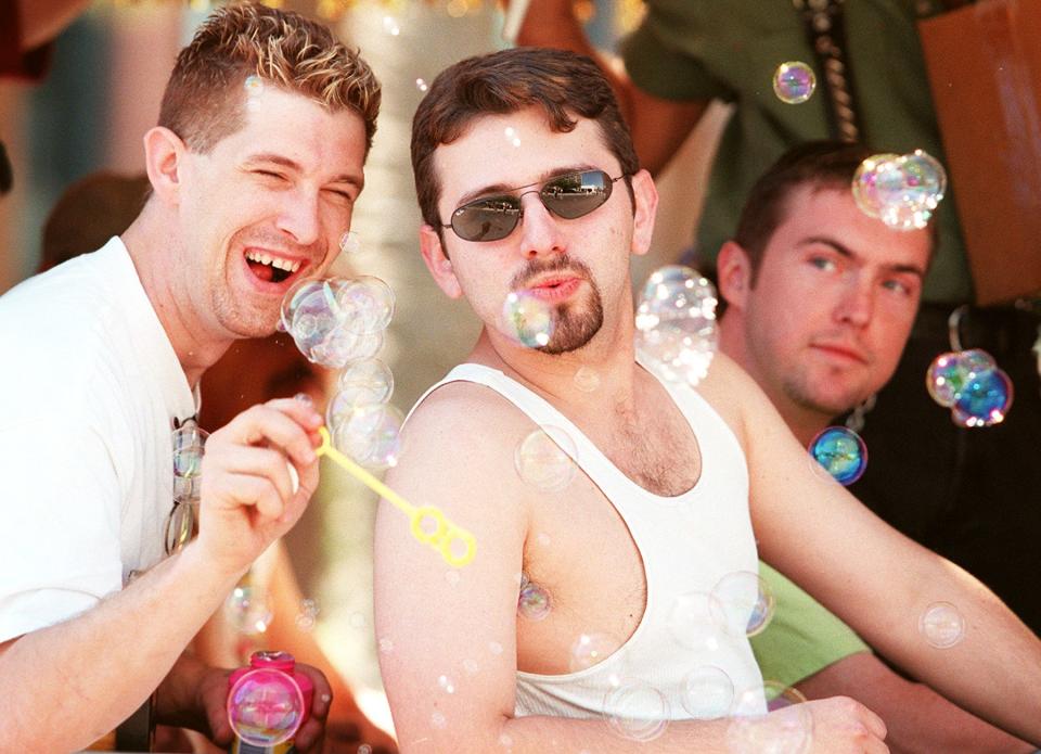 15276 -- On left:  Jeff Andringa lets Travis Edwards have a try at blowing  some bubbles in the Nu Towne Saloon Float in  Phoenix's 3rd Annual Gay Pride Parade.   The float was filled with family , friends and employees.  Photo by Christine Keith on 4/17/99.
