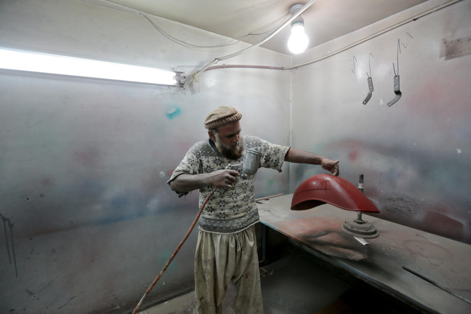 <p>A worker sprays a restored mudguard for a scooter at a Vespa restoration and repair workshop in Islamabad, Pakistan Feb. 27, 2018. (Photo: Caren Firouz/Reuters) </p>