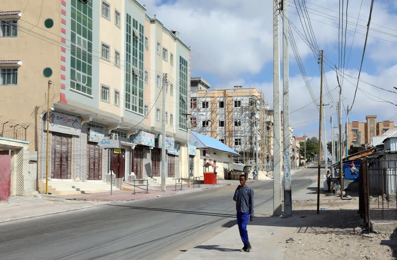 A Somali man walks on a street which is sealed off to prevent a protest over delayed elections in Mogadishu