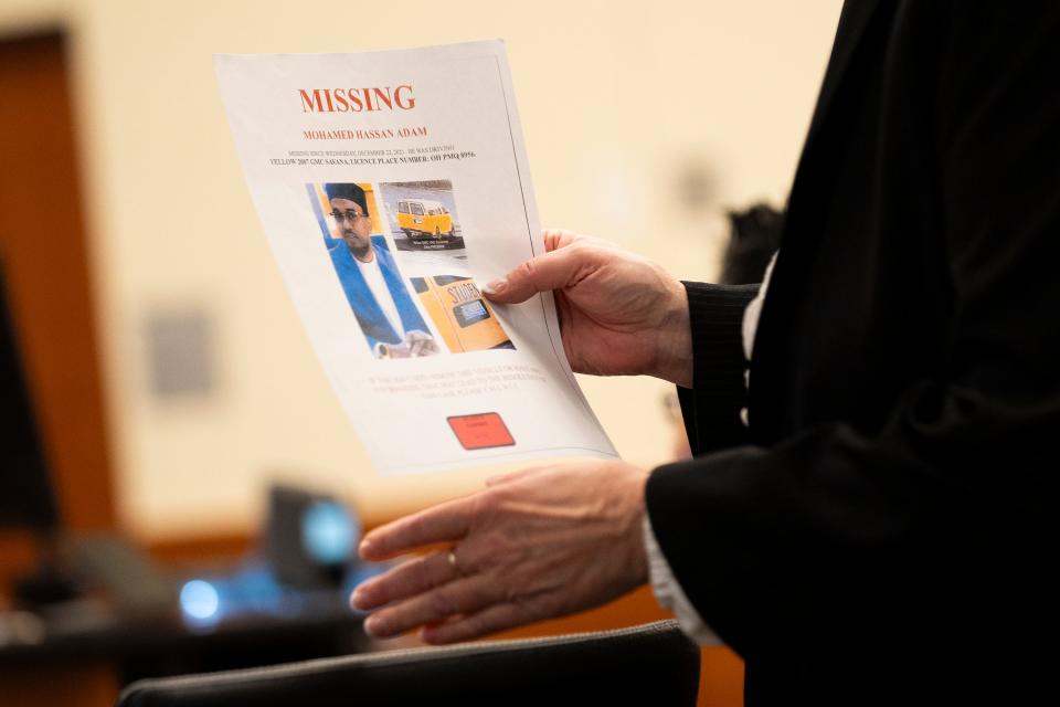 Assistant Franklin County Prosecutor Debra Gorrell holds up a missing flyer on Monday in the trial of John W. Wooden in Franklin County Common Pleas Court. John W. Wooden is accused of kidnapping and killing prominent local Imam Mohamed Hassan Adam in December 2021.