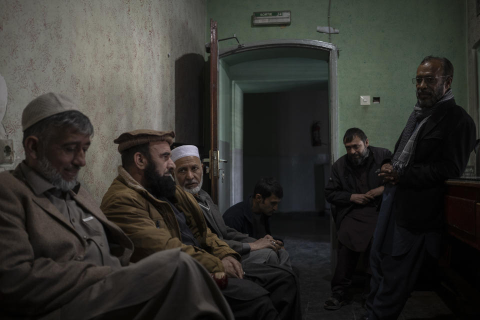 Staff members sit inside the ticket office of the Ariana Cinema in Kabul, Afghanistan on Monday, Nov. 8, 2021. They still show up at work every day hoping they will eventually get paid, despite the Taliban's orders to stop operating. (AP Photo/Bram Janssen)
