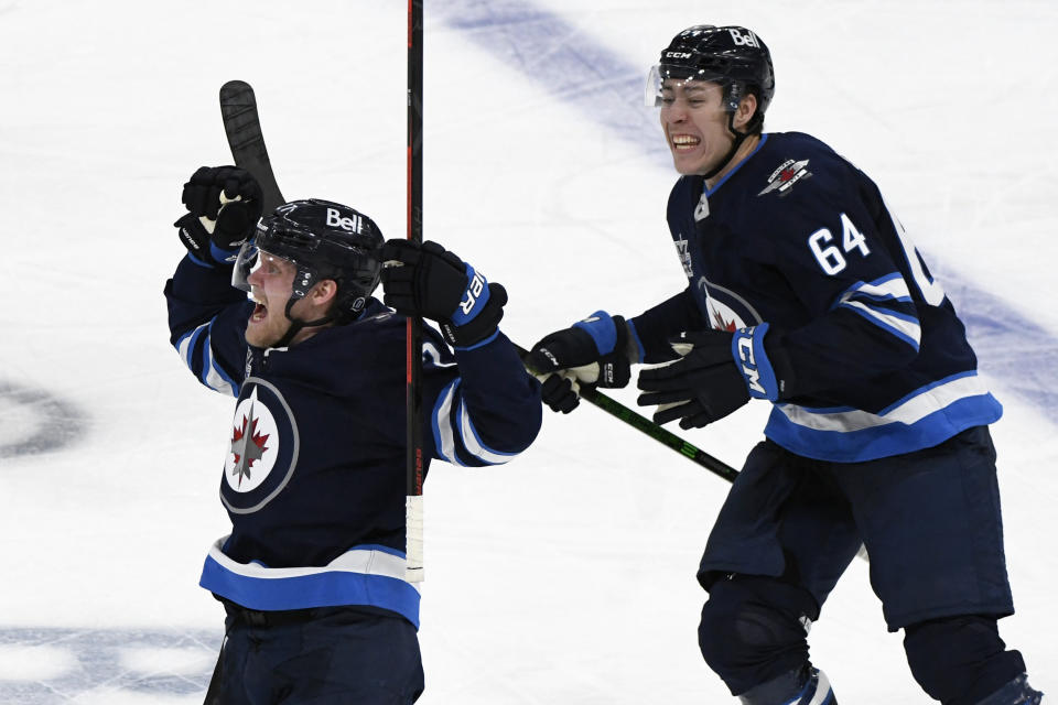 Winnipeg Jets' Nikolaj Ehlers (27) celebrates his game-winning goal with teammate Logan Stanley (64) in the first overtime period of an NHL hockey Stanley Cup playoff game against the Edmonton Oilers, Sunday, May 23, 2021, in Winnipeg, Manitoba. (Fred Greenslade/The Canadian Press via AP)