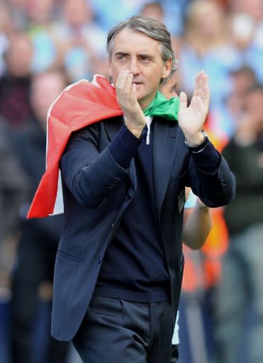 Manchester City's Italian manager Roberto Mancini celebrates on the pitch after their 3-2 victory over Queens Park Rangers in the English Premier League football match between Manchester City and Queens Park Rangers at The Etihad stadium in Manchester