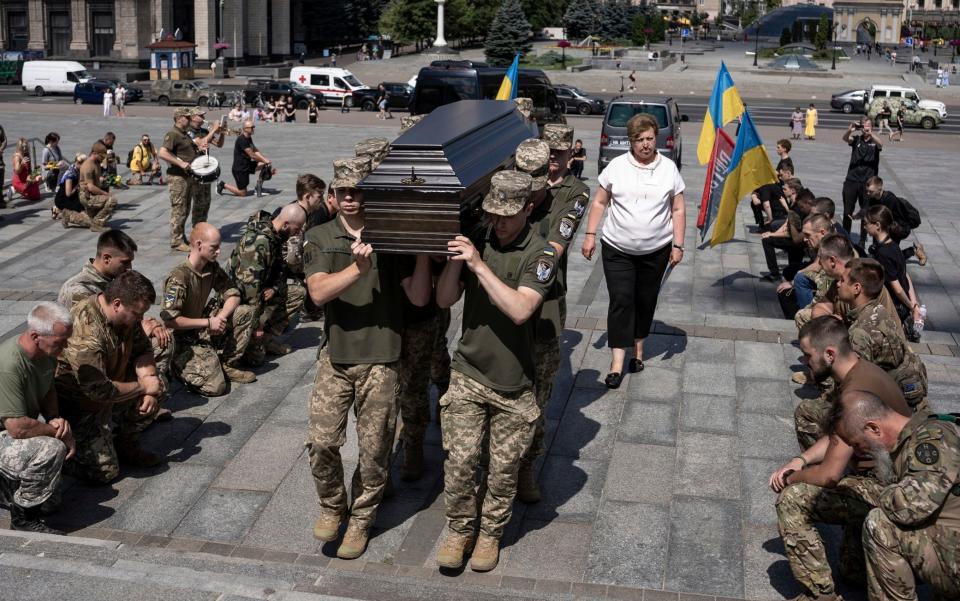 Ukrainian servicemen carry the coffin of British combat medic, volunteer, Peter Fouche, 49 who was killed on June 27 during his work in East Ukraine