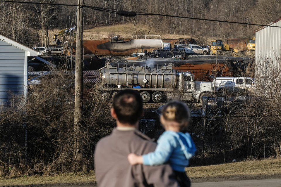 A family from Pennsylvania inspects the wreckage of the Norfolk Southern train derailment in East Palestine, Ohio on Feb. 19, 2023. (Matthew Hatcher / Bloomberg via Getty Images)