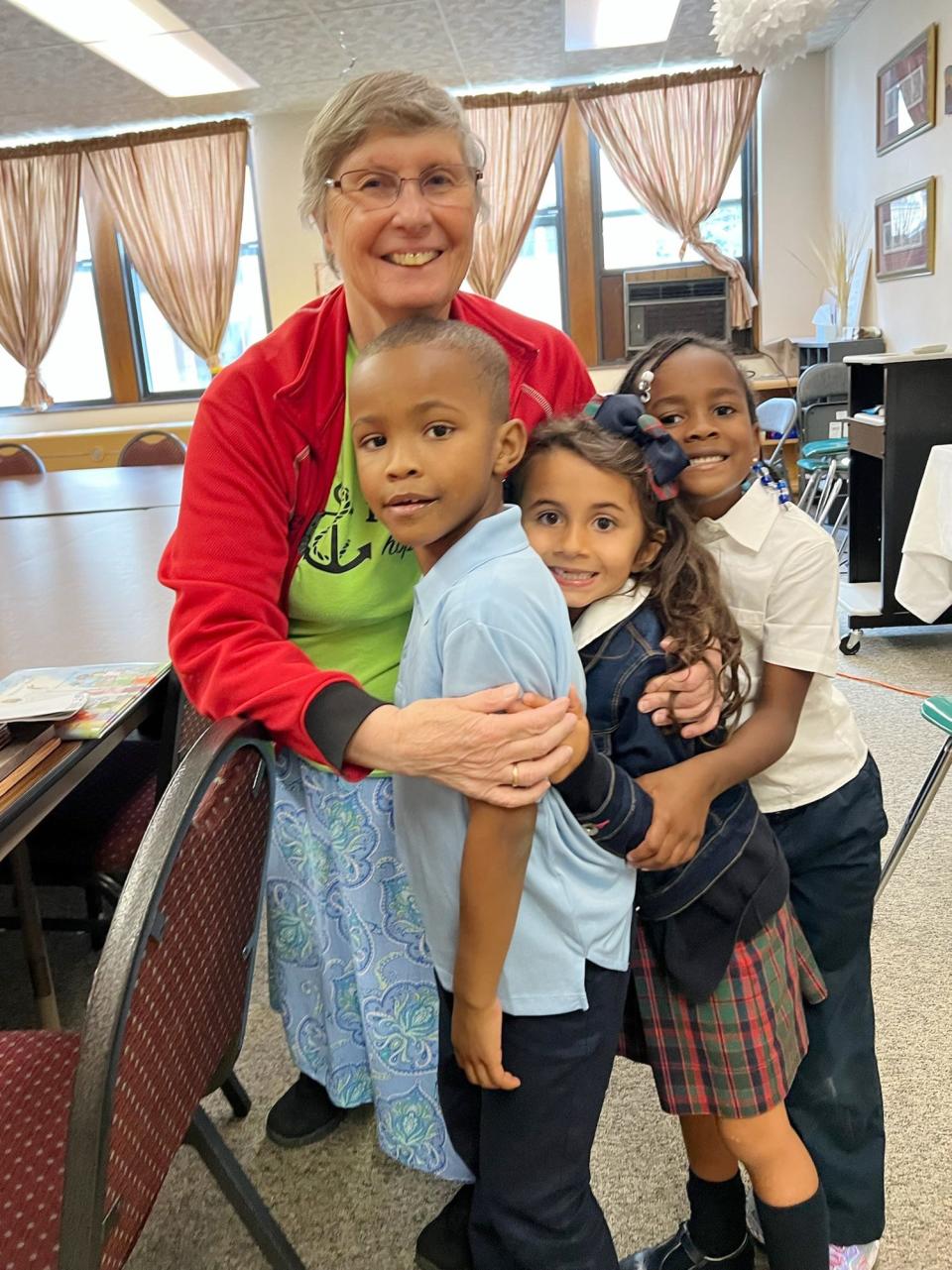Sister Kathy Avery, 80, former principal at St. Clare of Montefalco Catholic School in Grosse Pointe Park, embraces three students at the start of the 2023 school year. She is leaving St. Clare after 16 years of service and moving back to her motherhouse in Omaha, Nebraska.