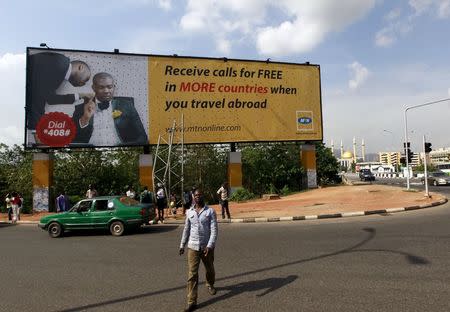 A man walks in front of an advertisement billboard of MTN phone company in Abuja, Nigeria May 25, 2015. REUTERS/Afolabi Sotunde