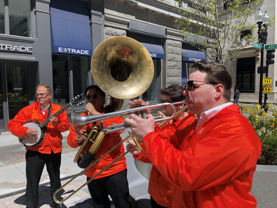 Dan Gabel, right, and fellow musicians perform in downtown Boston, Tuesday, May 10, 2022. Gabel has canceled Netflix and other streaming services and tried to cut back on driving as the costs of gas, food, and other items, such as the lubricants he uses for his instruments, has soared. In the photo, from left to right, are Eric Baldwin, banjo; Ed Goroza, sousaphone; Josiah Reibstein, trombone; and Gabel, trumpet. (AP Photo/Steve LeBlanc)