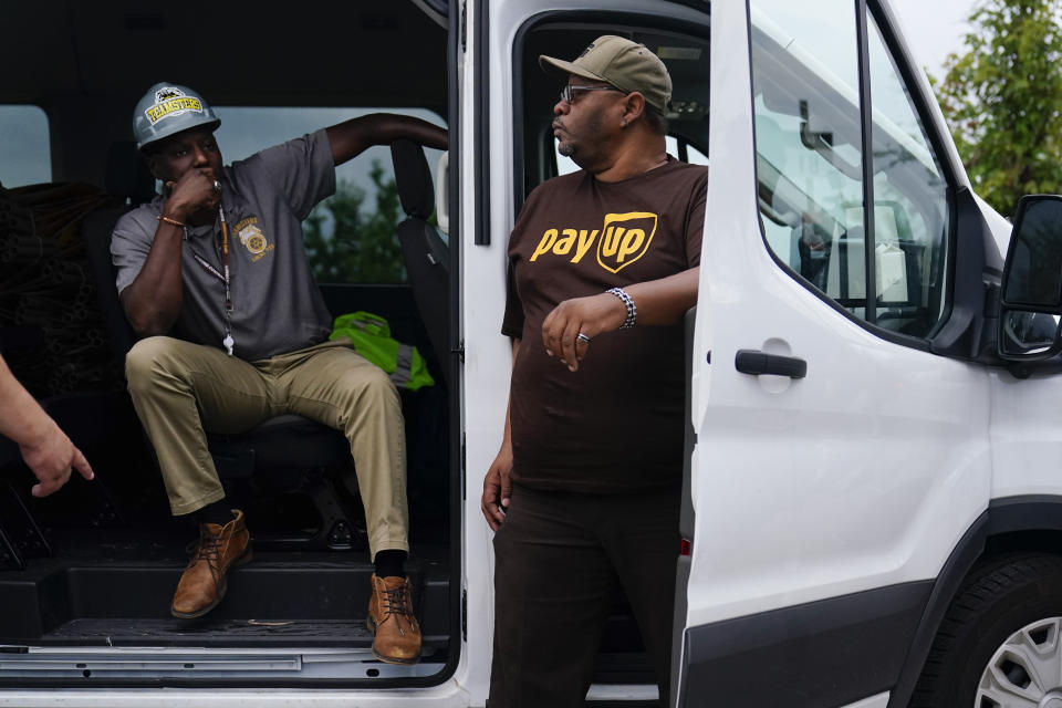 FILE - UPS teamsters and workers wait before a rally, Friday, July 21, 2023, in Atlanta, as a national strike deadline nears. UPS has reached a contract agreement with its 340,000-person strong union Tuesday, July 25, averting a strike that had the potential to disrupt logistics nationwide for businesses and households alike. (AP Photo/Brynn Anderson, File)