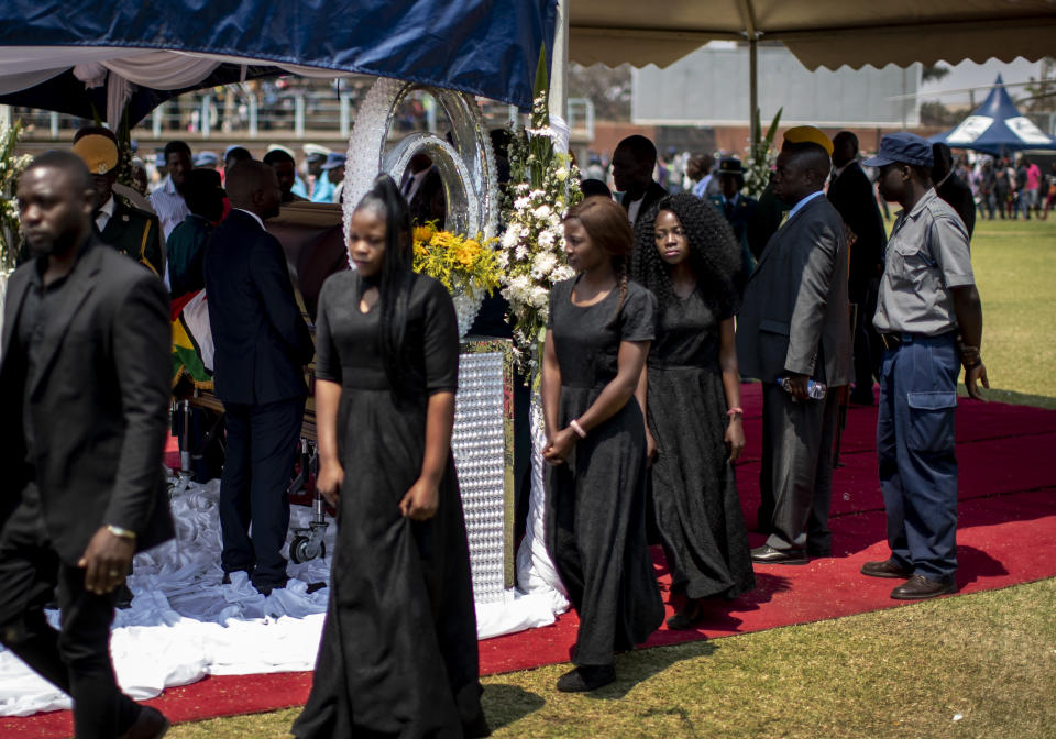 Members of the public walk out after viewing the body of former president Robert Mugabe as it lies in state at the Rufaro stadium in the capital Harare, Zimbabwe Friday, Sept. 13, 2019. The ongoing uncertainty of the burial of Mugabe, who died last week in Singapore at the age of 95, has eclipsed the elaborate plans for Zimbabweans to pay their respects to the former guerrilla leader at several historic sites. (AP Photo/Ben Curtis)