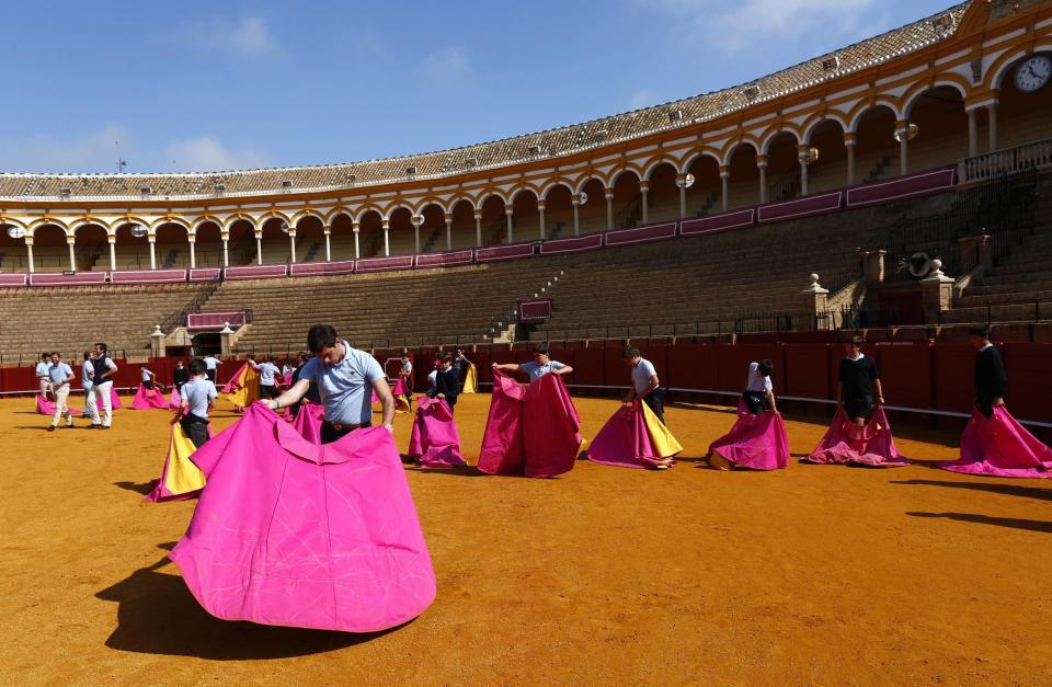 Students hold capotes during bullfight master class for schoolchildren at Maestranza bullring in Andalusian capital of Seville