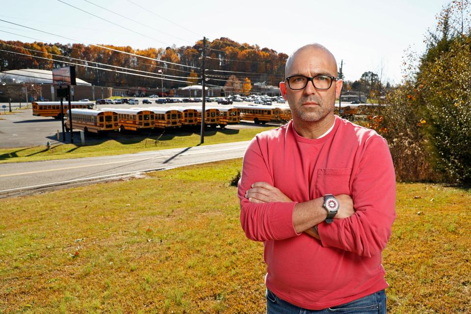 Matt Hawn stands across the street from the former Sullivan Central High School Nov. 12, 2021, in Kingsport, Tenn. Hawn was fired from the school after school officials said he used materials with offensive language and failed to provide a conservative viewpoint during discussions of white privilege in his contemporary issues class, which has since been eliminated. (AP