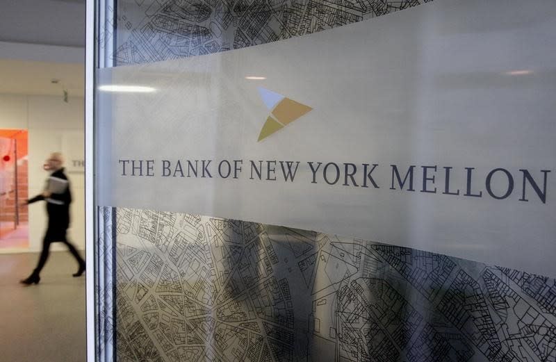 A woman walks past a logo at the office of the Bank of New York Mellon in Brussels, February 25, 2010. REUTERS/Sebastien Pirlet