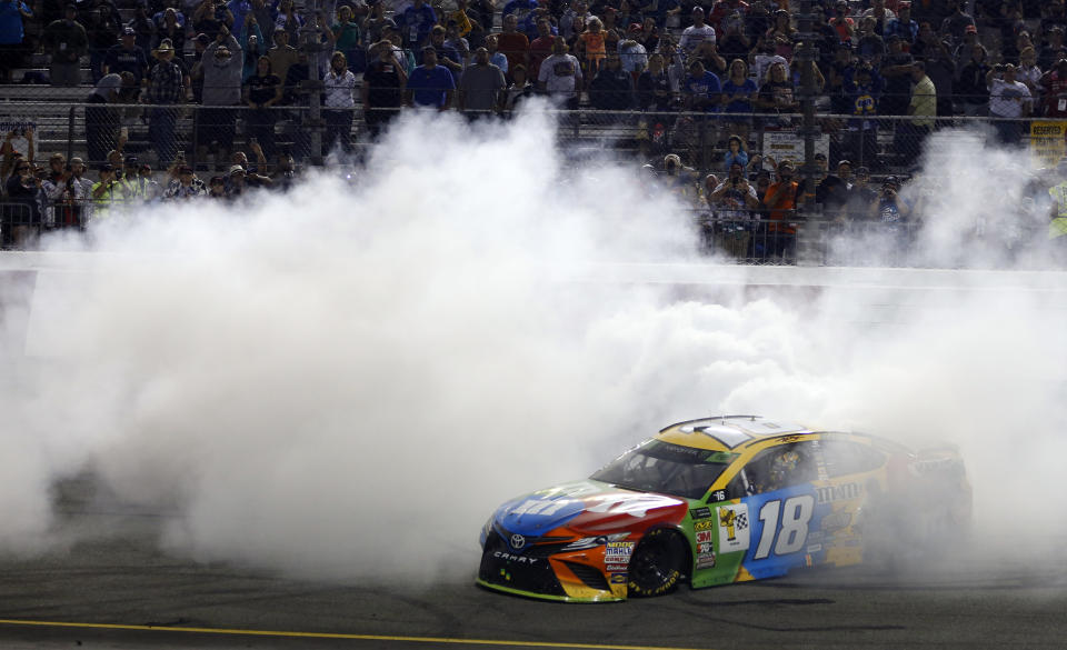 Kyle Busch (18) does a burnout as he celebrates winning the NASCAR Cup Series auto race at Richmond Raceway in Richmond, Va., Saturday, Sept. 22, 2018. (AP Photo/Steve Helber)