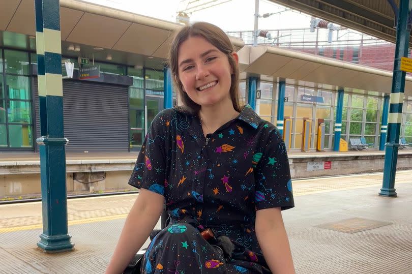 Zara Beth smiling and sat in her wheelchair