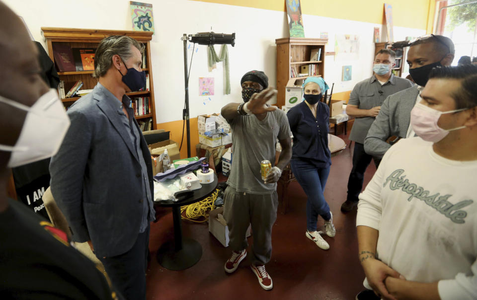 California Gov. Gavin Newsom, second from left, listens to the concerns of Marcus Warren, center, while visiting the Hot and Cool Cafe in Leimert Park in Los Angeles on Wednesday, June 3, 2020. The cafe has been providing meals prepared at the establishment three days a week for older adults during the coronavirus pandemic stay at home order. (Genaro Molina/Los Angeles Times via AP, Pool)