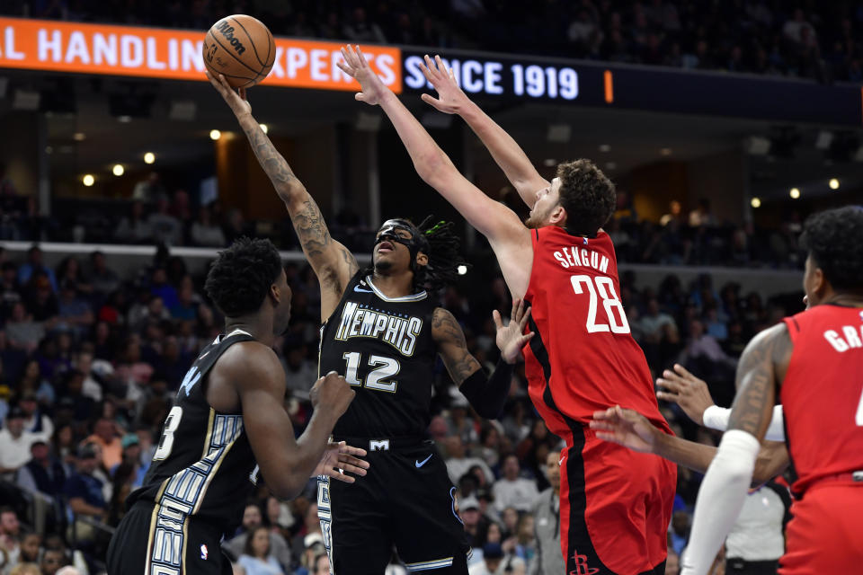 Memphis Grizzlies guard Ja Morant (12) shoots against Houston Rockets center Alperen Sengun (28) in the second half of an NBA basketball game Friday, March 24, 2023, in Memphis, Tenn. (AP Photo/Brandon Dill)