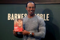 Golfer Tiger Woods poses with a copy of his new book "The 1997 Masters: My Story" at a book signing event at a Barnes & Noble store in New York City, New York, U.S., March 20, 2017. REUTERS/Mike Segar