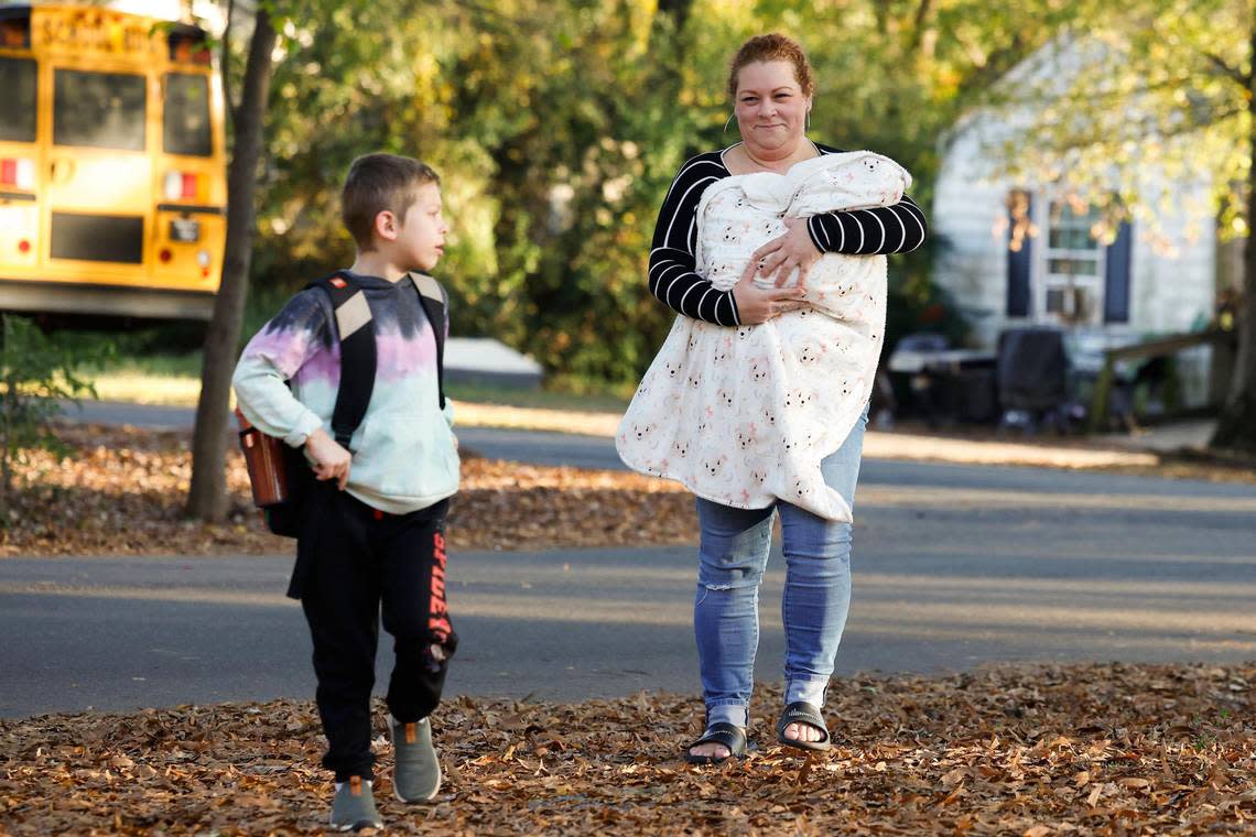 Erin O’Malley holds her newborn daughter named Lennox as she walks with her nephew Mateo Mengering, 6, who just returned home from school. in Charlotte., Monday, Nov. 14, 2022.