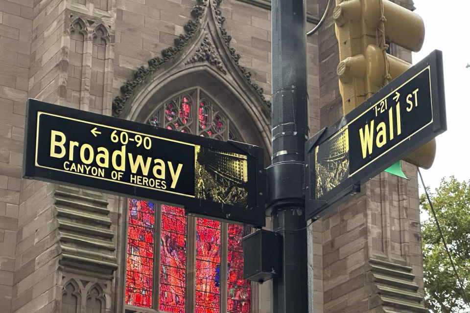 FILE - Signs mark the intersection of Broadway and Wall Street in the Financial District on Oct. 2, 2024, in New York. Trinity Church is in the background. (AP Photo/Peter Morgan, File)