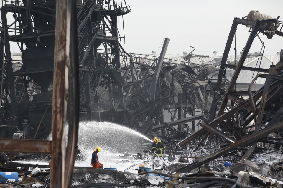 Firefighters spray foam amid twisted metal frames of a charred chemical factory Tuesday, July 6, 2021 in Samut Prakan, Thailand.Firefighters finally extinguished a blaze at a chemical factory just outside the Thai capital early Tuesday, more than 24-hours after it started with an explosion that damaged nearby homes and then let off a clouds of toxic smoke that prompted a widespread evacuation. (AP Photo/Anuthep Cheysakron)