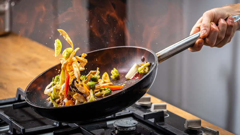 tossing food in a wok