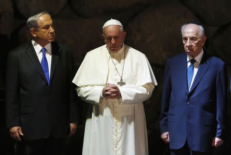 Pope Francis (C) stands in between Israeli Prime Minister Benjamin Netanyahu (L) and Israeli President Shimon Peres during a ceremony in the Hall of Remembrance at the Yad Vashem Holocaust memorial in Jerusalem May 26, 2014. REUTERS/Baz Ratner