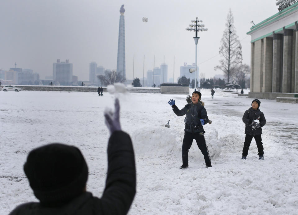 FILE - In this Dec. 16, 2018, file photo, North Korean boys play snowball fight on Kim Il Sung Square as the Tower of The Juche Idea is seen in the background in Pyongyang, North Korea, where the winter season has started. The word Juche is splashed across countless propaganda signs in North Korea and featured in hundreds of state media reports, and while it’s technically a political ideology, it can seem more like a religion because of its difficulty for many outsiders to grasp and ability to inspire devotion among North Koreans. (AP Photo/Dita Alangkara, File)