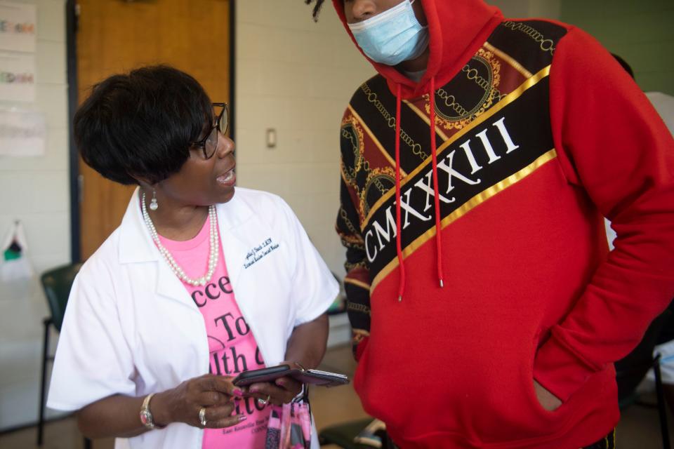 Cynthia Finch talks to a young person about getting vaccinated for COVID-19 on July 28 during vaccination outreach at the YWCA Phyllis Wheatley Center.