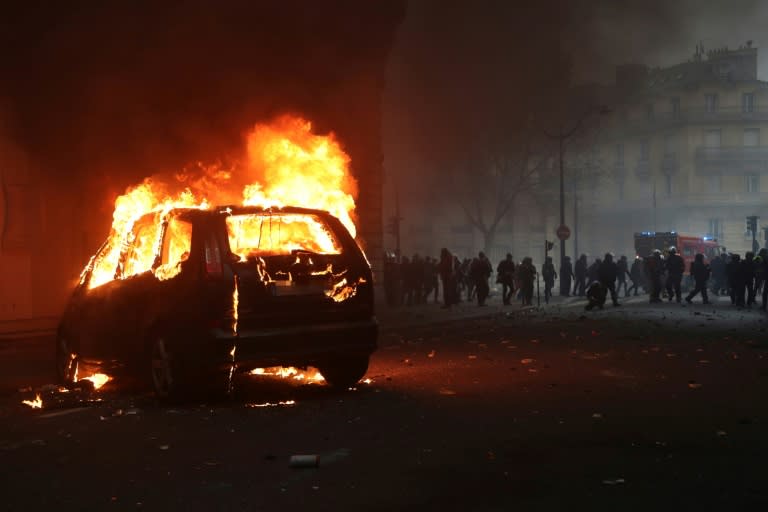 A car burning overnight during demonstrations in Paris which saw police and protesters clash