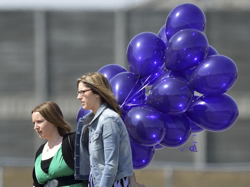 Guests carry a bunch of balloons at the funeral of Kaiti Perras at the First Alliance Church in Calgary