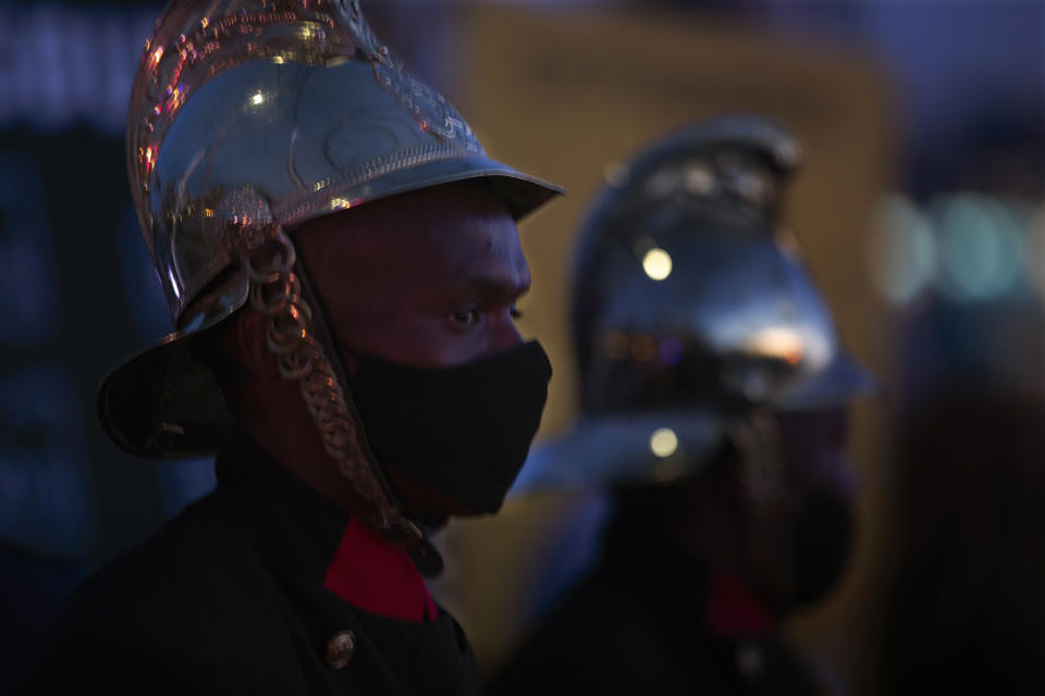 Firemen join frontline workers at a candlelight ceremony on New Year's Eve on the famed Nelson Mandela Bridge in downtown Johannesburg Thursday, Dec. 31, 2020. Many South Africans will swap firecrackers for candles to mark New Year's Eve amid COVID-19 restrictions including a nighttime curfew responding to President Cyril Ramaphosa's call to light a candle to honor those who have died in the COVID-19 pandemic and the health workers who are on the frontline of battling the disease. (AP Photo/Denis Farrell)